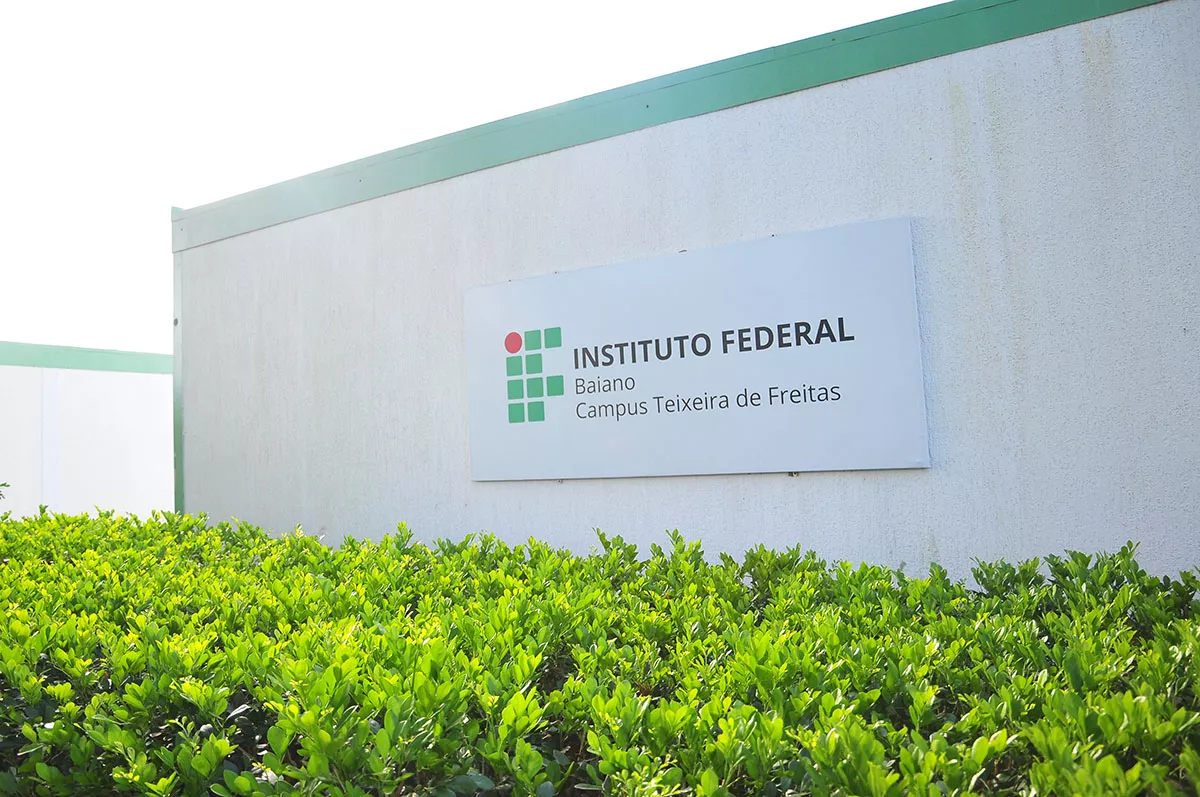 Fachada de prédio do IF Baiano em Teixeira de Freitas. Ao centro da imagem, uma placa com a logo da instituição.
